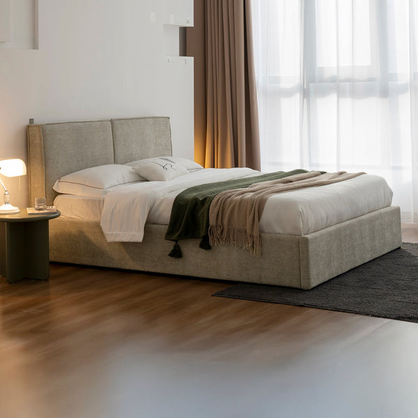 Cama Madrid tapizada en beige en una recámara con piso de madera y ventanales