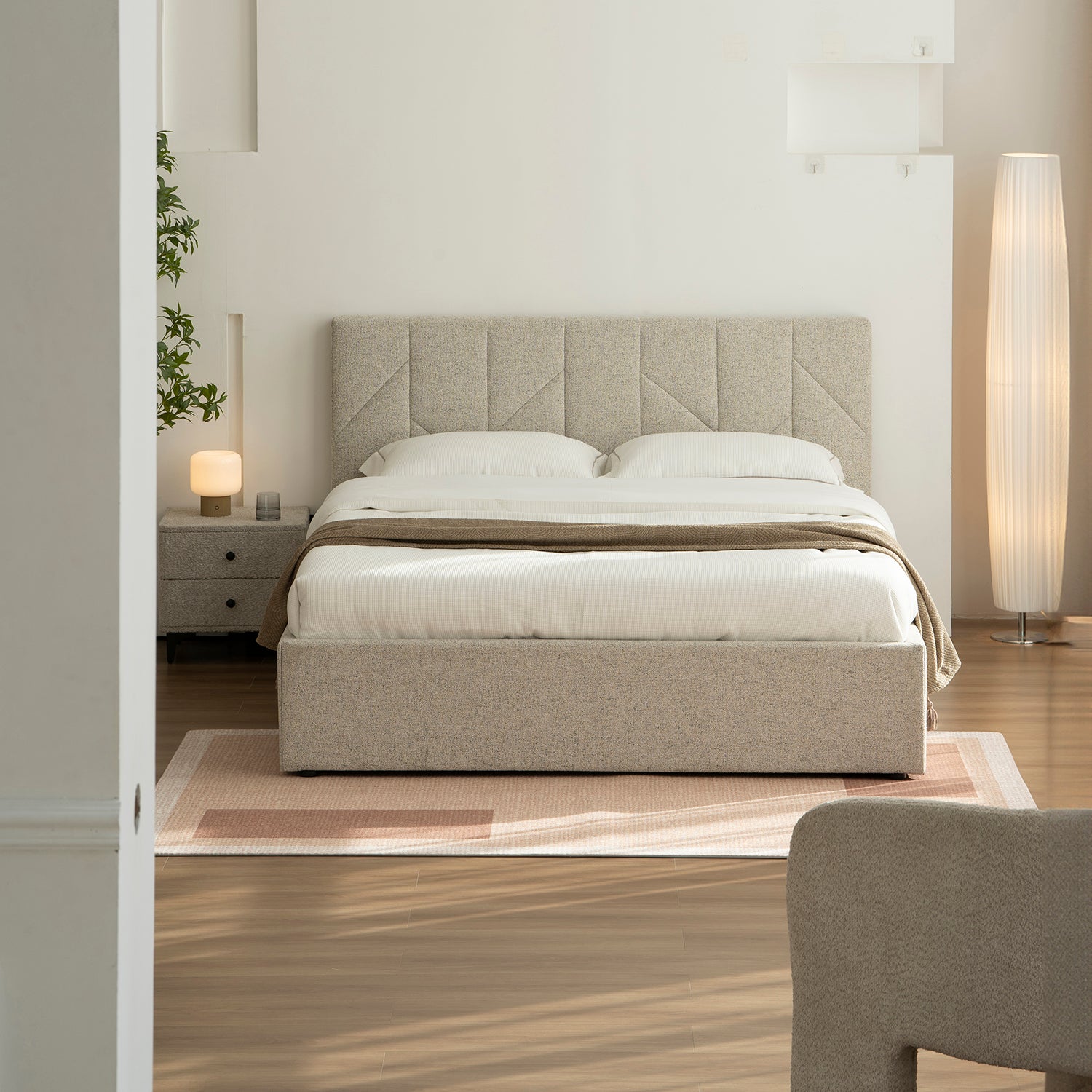 Foto Lifestyle de habitación con cama alicante al centro, un tapete en el suelo, piso de madera, buró lateral con textura.