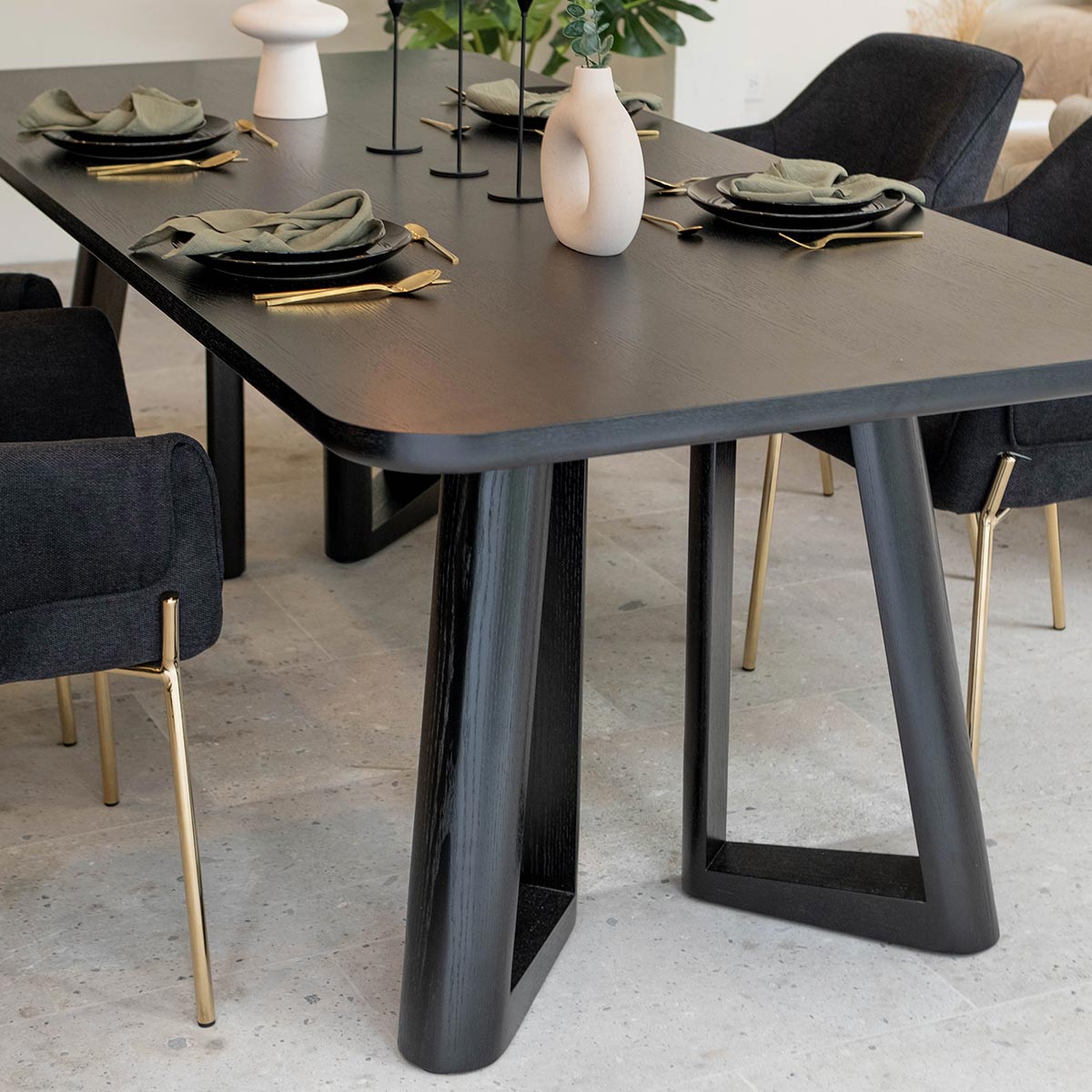 Detalle en pata Mesa de comedor Jaipur negra con Silla Toronto negra con patas doradas