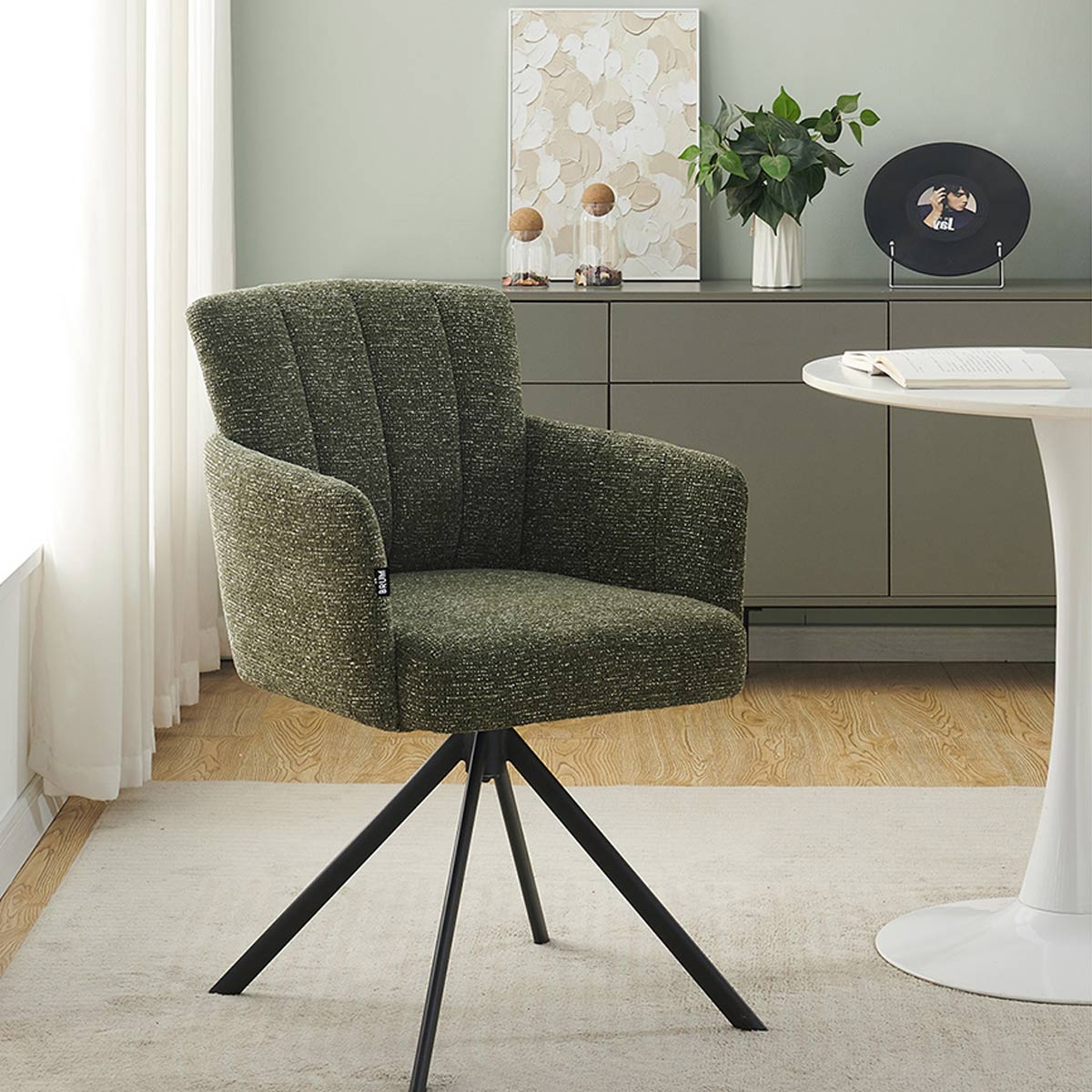 Silla Pontevedra verde lifestyle en una sala junto a una mesa blanca